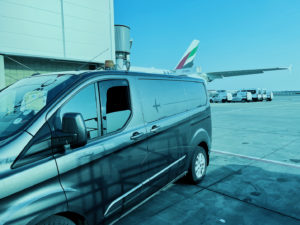 small cargo van parked on the tar mac of an airport